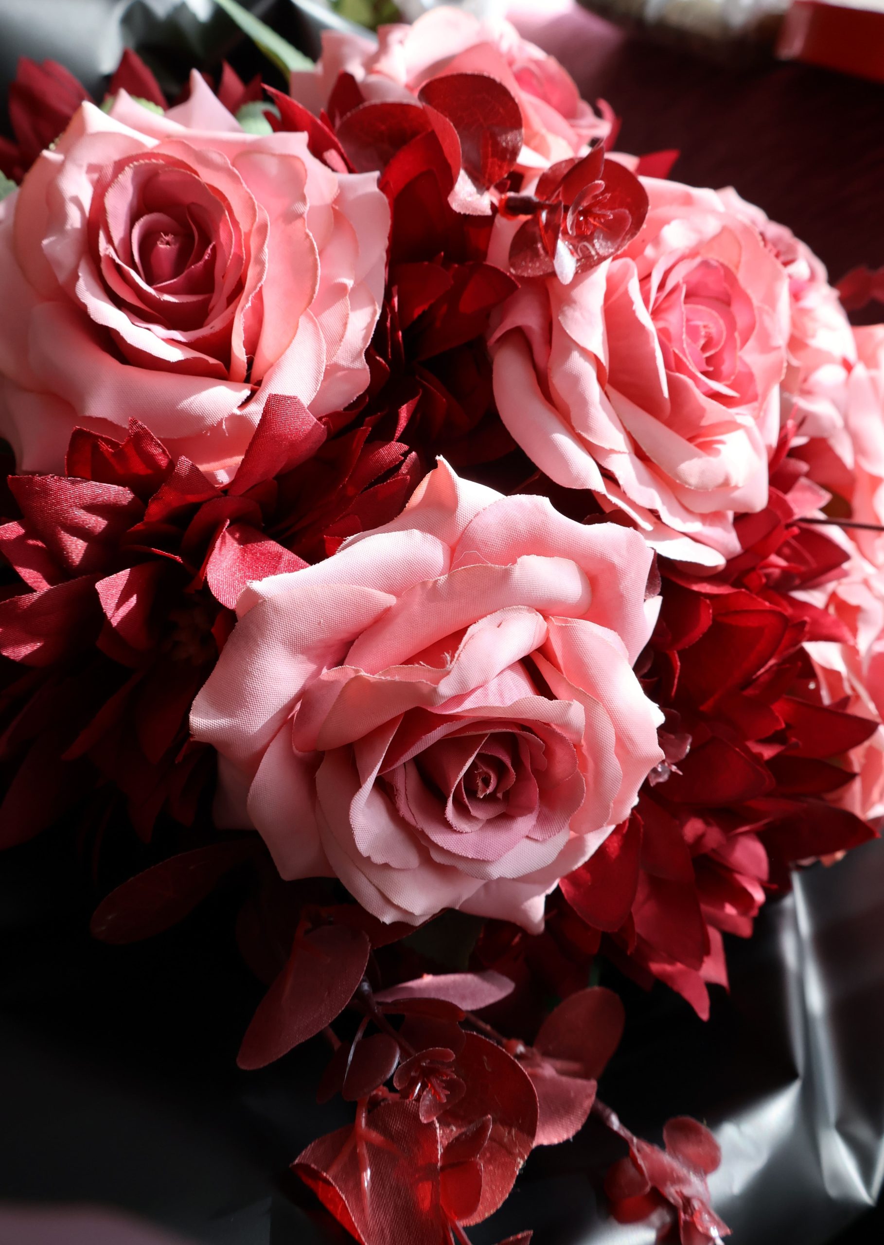 Pembe güller ve kırmızı yapraklarla hazırlanmış zarif çiçek aranjmanı – Mert’s Flora