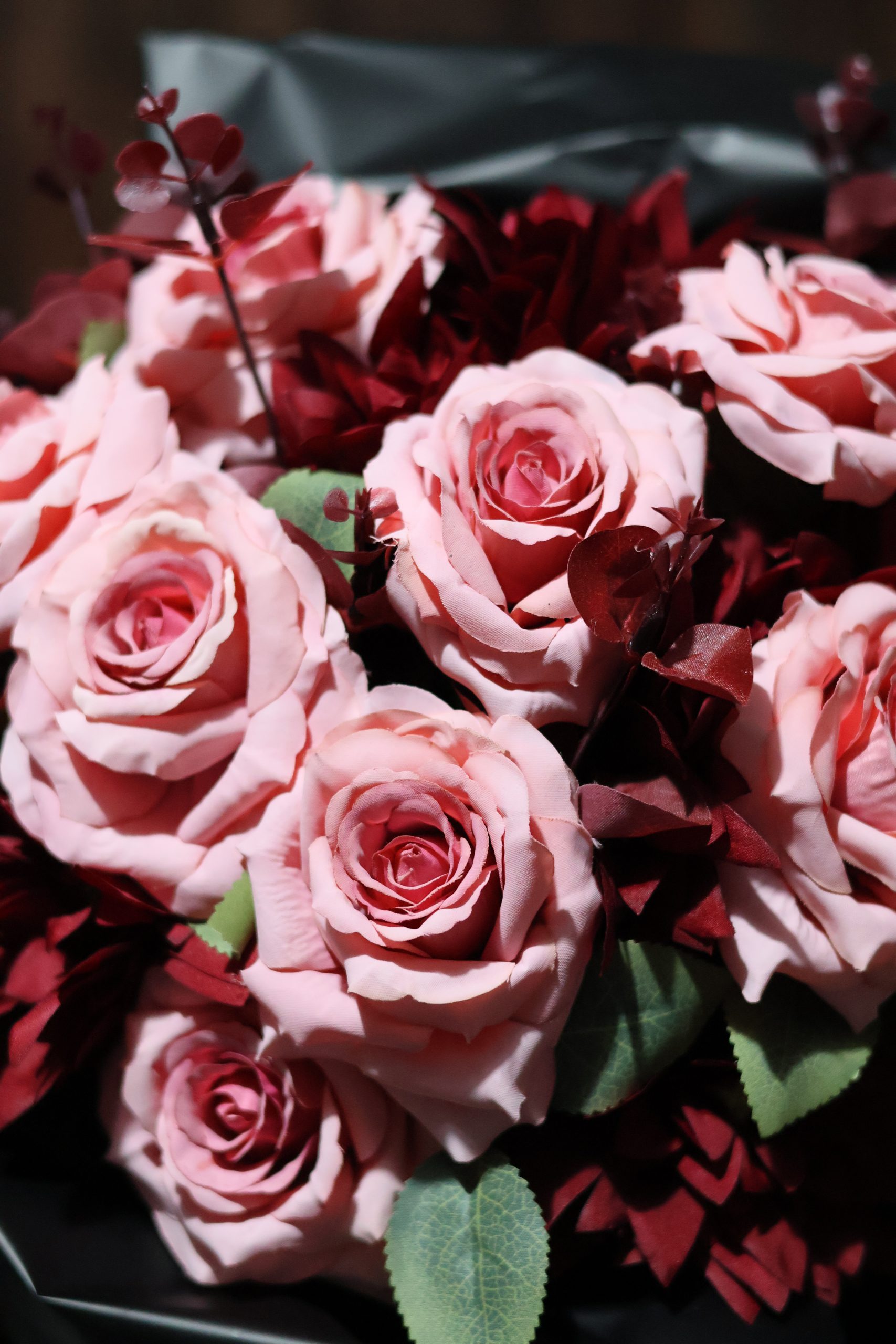 Pembe yapay gül buketi, kırmızı yaprak detaylarıyla