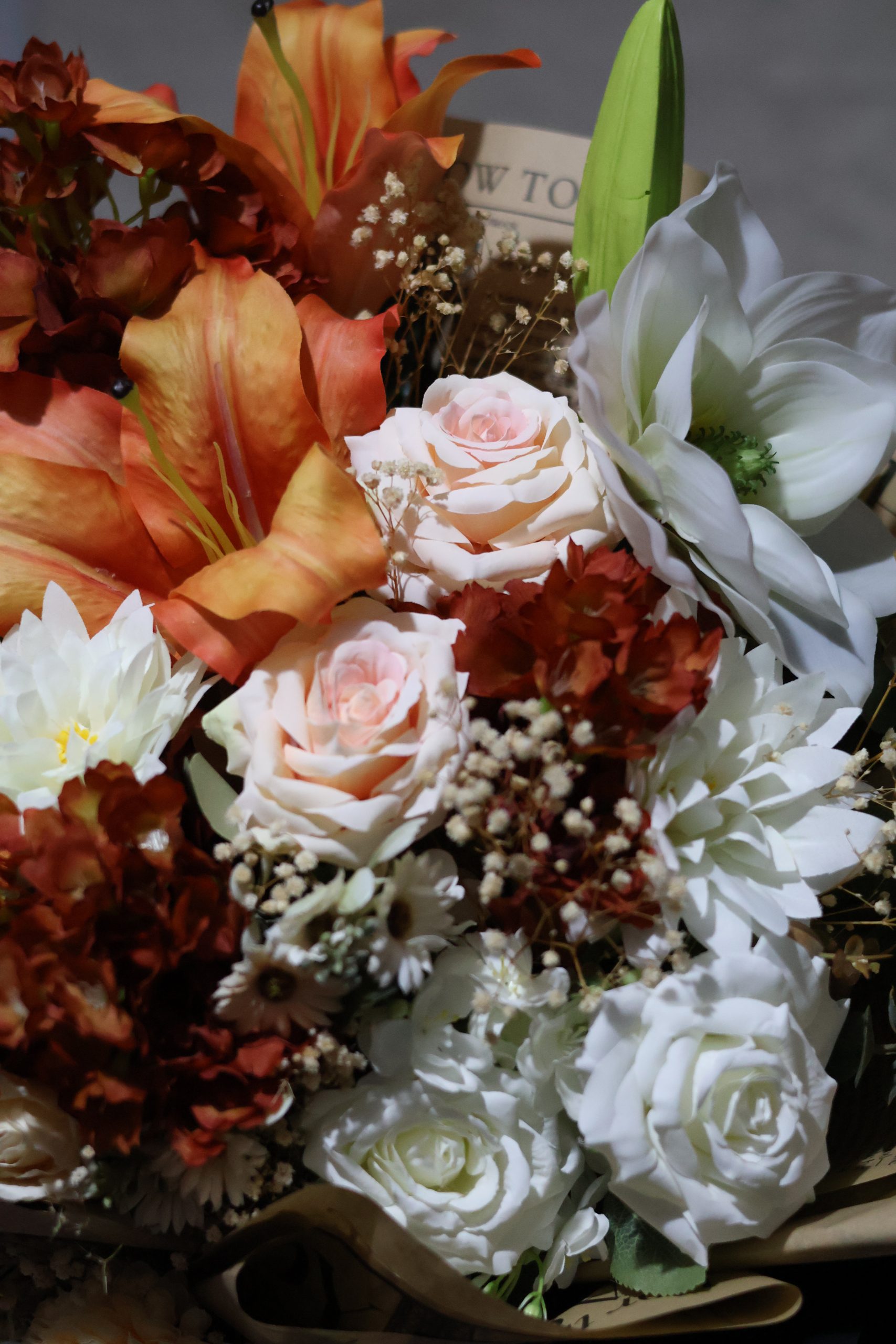 Turuncu lilyum, beyaz gül ve şakayık çiçekleriyle hazırlanmış yapay sonbahar buketi