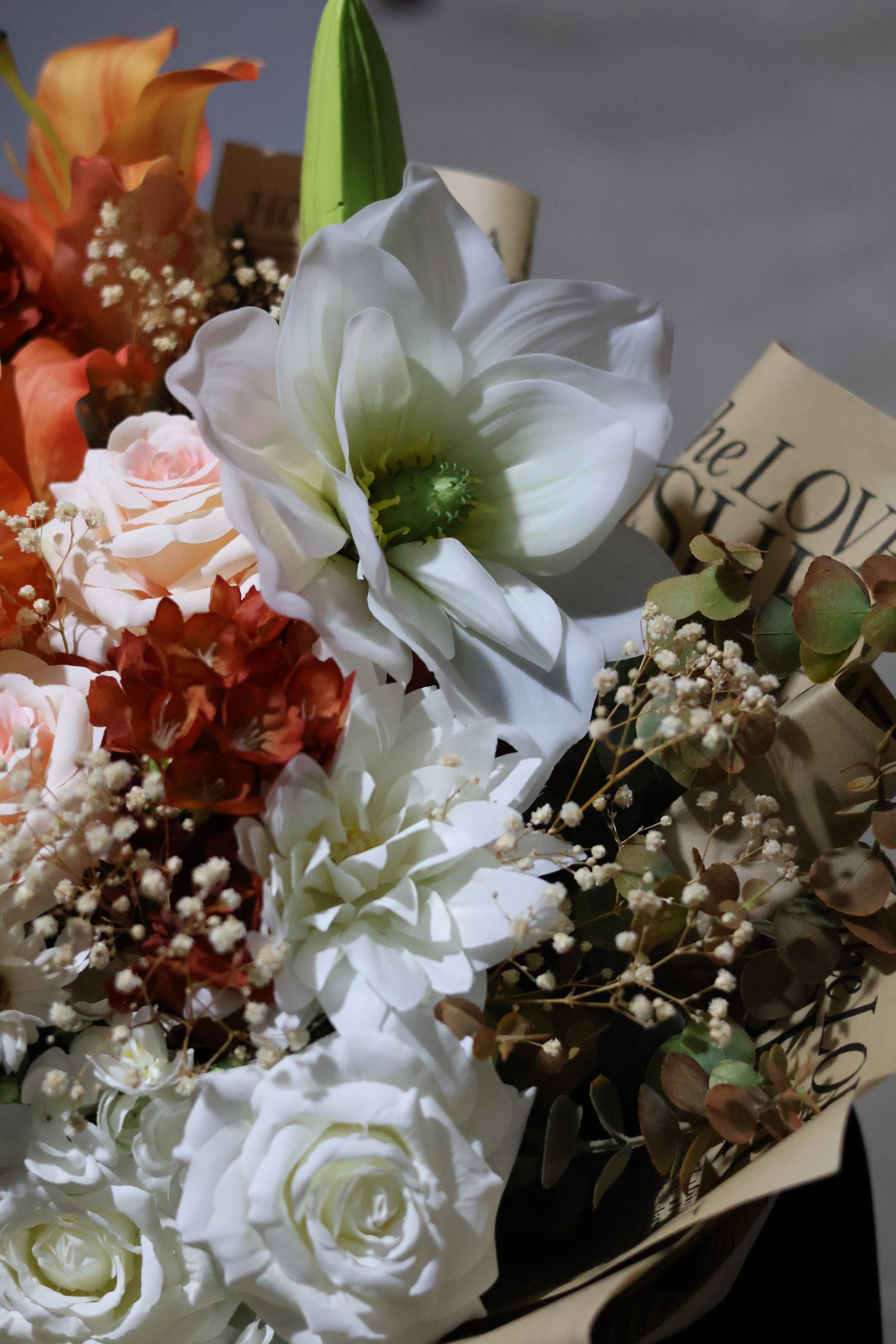 “Yapay sonbahar buketi – beyaz lilyum, gül ve turuncu çiçeklerden oluşan dekoratif aranjman